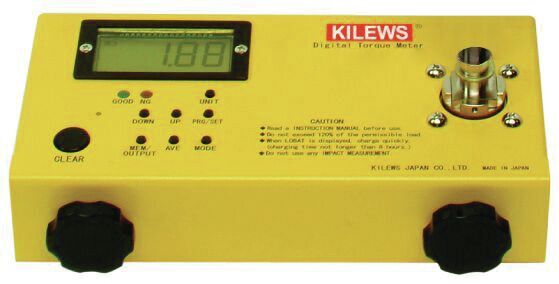 Das Bild zeigt ein gelbes Gerät mit einem digitalen Display und mehreren Tasten. Es hat Anschlüsse, um Messungen durchzuführen. Die Oberfläche ist flach, mit runden Reglern an den Seiten.