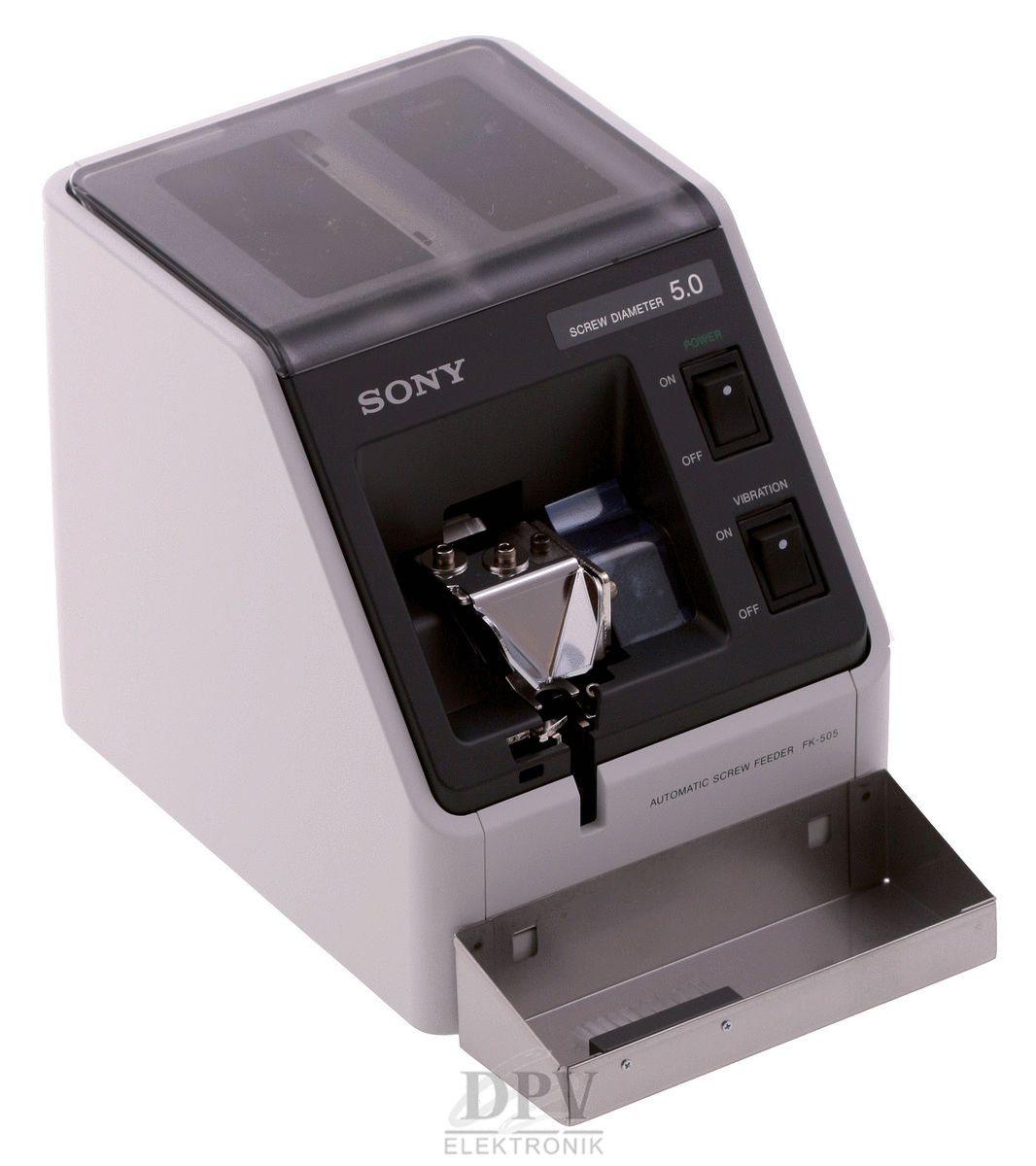 Das Bild zeigt einen automatischen Schraubenfütterer. Die Maschine ist in einem grauen Gehäuse mit einer transparenten Oberseite. Auf der Vorderseite befinden sich zwei Schalter und ein Öffnungsfach für Schrauben.