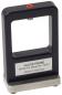 Preview: The image shows a rectangular device with an open frame, topped with a red button. It stands on a wide, stable base. A labeled metal plate is attached to the front.