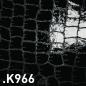 Preview: The image displays a black, shiny surface with a pattern of rectangular scales reminiscent of crocodile leather. The texture is irregular and slightly raised.