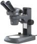 Preview: The image shows a microscope with two eyepieces, a stable base, and a round slide. It is gray in color and has several adjustment options for focusing.