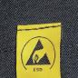 Preview: Das Bild zeigt ein gelbes Etikett mit einem schwarzen Symbol in Form eines Dreiecks und einer Hand. Darunter steht "ESD". Der Hintergrund ist aus dunkler Denim-Textur.
