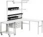 Preview: The image shows a modern L-shaped work desk. It has a white tabletop and several shelves. Above are black storage bins, and below are drawers. One side has wheels.