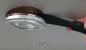 Preview: The image shows a handle lifting a round, silver ceiling lamp. The lamp has a transparent area in the middle and is encased in a dark, circular frame.