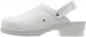 Preview: The image shows a white clog with a closed toe area and an adjustable strap at the heel. The sole is slightly elevated and has a grippy pattern.