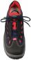 Preview: The image displays a sports shoe. It is primarily black with red and blue accents. The shoelaces are black, and the shoe features a thick, grippy sole. The design appears functional and modern.