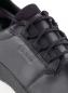 Preview: Das Bild zeigt einen schwarzen Schuh aus Leder, der mit Schnürsenkeln versehen ist. Die Oberfläche wirkt glatt und modern, und das Logo ist an der Seite sichtbar.