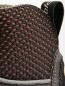 Preview: The image shows the upper part of a shoe. The surface is made of black mesh fabric with fine, orange dots. A thin, gray border runs along the bottom. A loop is visible at the top.
