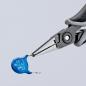 Preview: A pair of pliers holds a small blue component, which is round and flat with two connecting wires. The background is bright and unattended, focusing attention on the tool.