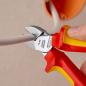 Preview: The image shows a hand holding a red and yellow pair of pliers. The pliers are cutting a gray cable attached to an orange outlet.