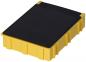 Preview: The image displays a rectangular box made of yellow plastic material. It has a smooth, black top and vertical grooves on the sides that provide stability.