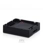 Preview: The image displays a black, square electronics box with slightly raised edges. The surface is plain and matte, with recesses on the sides. The background is white.