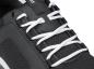 Preview: The image shows a black sports shoe with white, braided laces. The surface texture appears breathable, featuring a simple, modern design.
