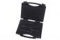 Preview: The image shows a black suitcase with an open flap. Inside, several long, thin tools are arranged in a row, lying on a soft, velvety surface.