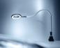 Preview: Die Abbildung zeigt eine flexible Schreibtischlampe mit einem runden, vergrößernden Licht. Der Hals der Lampe ist biegsam und sie steht auf einem stabilen, schwarzen Fuß. Der Hintergrund ist in sanften Grautönen.