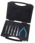 Preview: The image displays a black toolset with a folding box. Inside the box, there are six fine tools and a pair of pliers with blue handles. The tools are precise and slim.