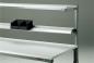 Preview: The image shows a shelf with several horizontal shelves. On the top shelf, there are two black storage boxes. The shelf has a metal structure.