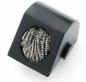 Preview: The image shows a black, slanted block with a round opening. Inside, there is a silver metal grid. It could be a cleaning brush.