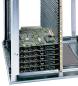 Preview: The image shows an open server or computer. Inside, there are several green circuit boards (PCBs) stacked on top of each other, accompanied by silver, vertical cooling fins. The structure is metallic and rectangular.