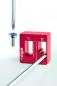 Preview: The image shows a red Wiha tool that has a fixture for screws. Next to the tool, a screw and a screwdriver are visible, floating in the foreground.