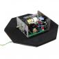 Preview: The image shows an electronic device on a hexagonal base. It consists of a casing with various cables and components, including a green circuit board and several connectors.