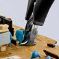Preview: Auf einer Leiterplatte sind blaue elektronische Bauteile zu sehen. Eine Zange greift ein Bauteil. Der Hintergrund ist hell, die Zange hat schwarze Griffe.