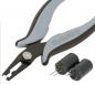 Preview: The image shows a special pair of pliers with flat, pointed jaws, ideal for electronic work. Next to the pliers, there are two black capacitors with two metal pins.