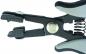 Preview: The image shows a black, ergonomically shaped pliers with gray handles. The pliers have a spring-loaded opening and two pointed gripping arms at the front, which can be moved together.
