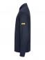 Preview: It shows a dark blue long-sleeve shirt with a collar. There is a yellow label on one sleeve. The surface has a fine texture.