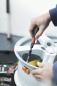 Preview: A hand holds a screwdriver tightening a screw on a silver rim. In the background, tools and a bright environment are faintly visible.