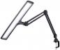 Preview: The image shows a black LED work light with a long, rectangular lampshade. It has a flexible arm and a clamp for attaching to tables.