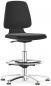 Preview: A black office stool with an oval seat and a slightly curved backrest. It features an adjustable foot ring and a silver, five-spoke base with casters.