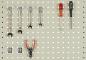 Preview: On a perforated panel, various tools are arranged: five wrenches in the top row, below them pliers with red handles, and two screwdrivers on the right side.