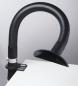 Preview: The image shows a flexible, black hose attached to a table. At the end of the hose, there is a round, open shaft. The hose is likely used for extracting fumes or dust.