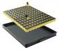 Preview: The image shows a detachable plate with many small, black and yellow buttons on a black, flat tray. The buttons are arranged in a regular pattern.