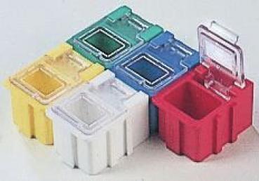 Das Bild zeigt fünf kleine, quadratische Kunststoffboxen in verschiedenen Farben: Gelb, Grün, Blau, Weiß und Rot. Einige haben transparente Deckel. Sie sind stapelbar und haben abgerundete Kanten.