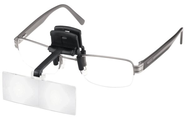 The image shows a clip holding a transparent lens. The lens has a rounded shape and is attached to a black clip. It is used to enhance vision.