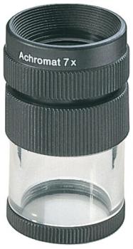 Das Bild zeigt ein schwarzes Mikroskopobjektiv mit einer transparenten Linse in der Mitte. Es ist zylindrisch, mit einem Gewinde oben und Rillen für besseren Halt. Auf dem Objektiv steht "Achromat 7 x".