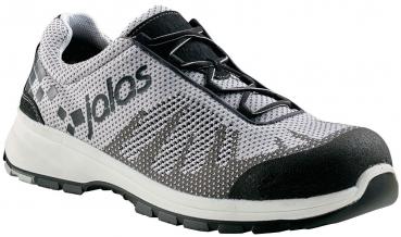 The shoe is black with red details and a white sole. It has diamond-shaped patterns on the sides and laces. The front part is reinforced for better protection. It looks sporty and sturdy.
