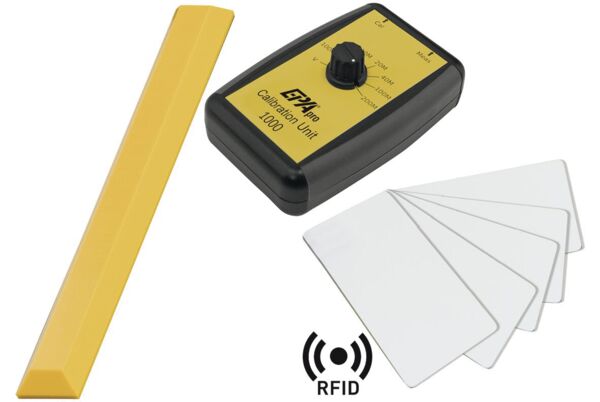 The image shows a yellow calibration device with a black casing. In the center, there is a large dial with various numerical markings (1M to 200M) and two arrows at the top for calibration and measurement.
