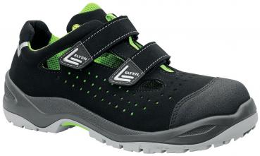 It is a black shoe with green accents. It has two velcro straps and a breathable upper with small holes. The sole is grayish and sturdy.
