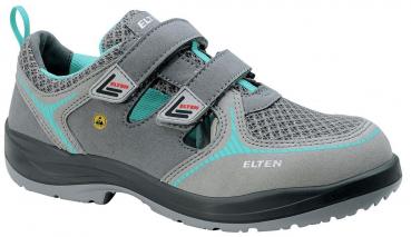 Der Schuh ist grau mit blauen und schwarzen Akzenten. Er hat zwei Klettverschlüsse, atmungsaktives Material und eine stabile, rutschfeste Sohle, ideal für aktive Nutzung.