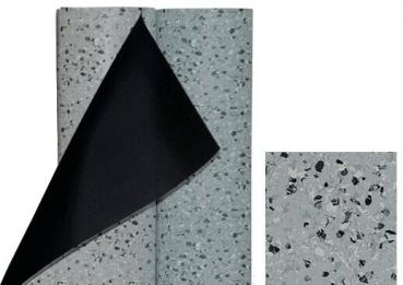 The image shows a gray flooring material with small, dark and light particles. Part of the material is rolled up, revealing the underlying black layer. Next to it is a small piece of the same material.