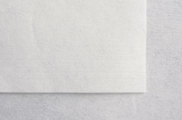 The image shows a piece of light, almost white paper on a gray background. The surface of the paper has fine, subtle lines.