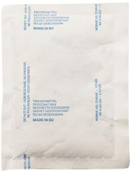 Das Bild zeigt ein weißes, rechteckiges Beutelchen. Darauf steht in blauer Schrift ?TROCKNMITTEL? und verschiedene Sprachen, die auf die Funktion als Feuchtigkeitsabsorber hinweisen.