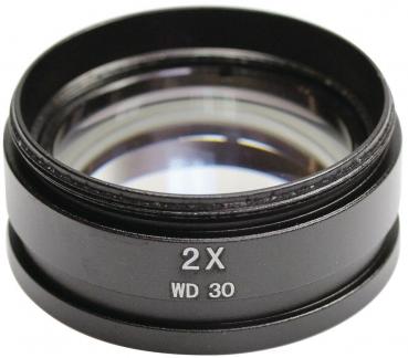 Das Bild zeigt eine schwarze Linse mit einer zweifachen Vergrößerung. Die Linse hat einen runden Rand und ist in der Mitte transparent. Auf der Seite steht "2X WD 30".