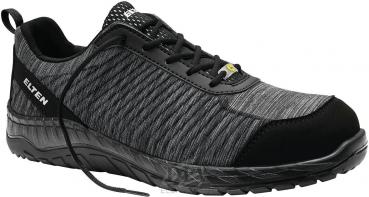 The shoe is a black sneaker with a textured surface. It has a flexible sole and features a sporty design with laces. The brand 