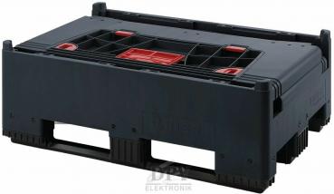 Das Bild zeigt eine robuste, schwarze Transportbox mit einem strukturierten Boden. An den Seiten befinden sich zwei große Öffnungen zum Tragen. Die Oberseite hat rot markierte Elemente.
