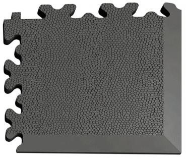 The image shows a black rubber mat with a textured surface and a wavy edge. The mat has sufficient corners and edges for puzzle-like connectors.