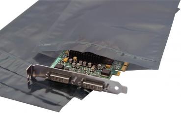 Das Bild zeigt eine Grafikkarte, die teilweise aus einer durchsichtigen, grauen Verpackung ragt. Die Karte hat einen Metallrand mit zwei Anschlussportenn und zeigt verschiedene elektronische Komponenten.